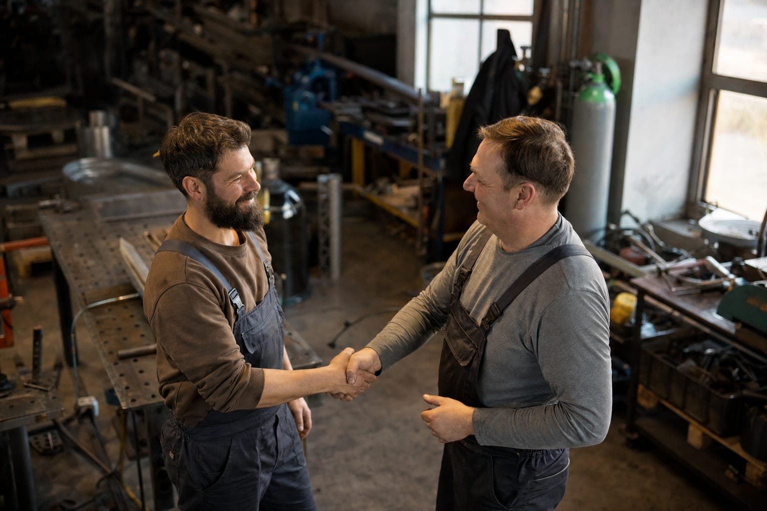 Handschlag zwischen zwei Handwerkern in der Werkstatt